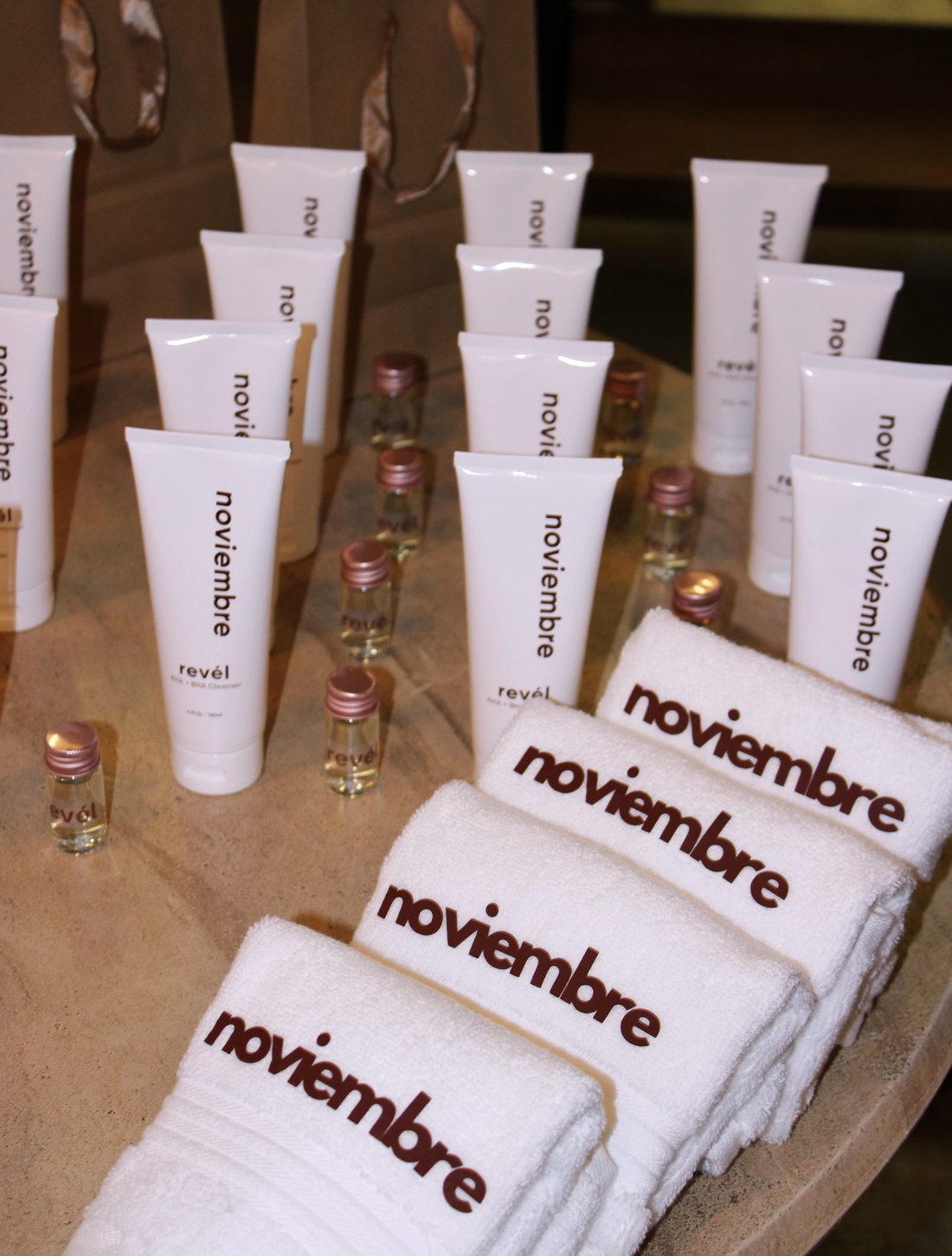 Revél Cleanser tubes and embroidered towels on the table